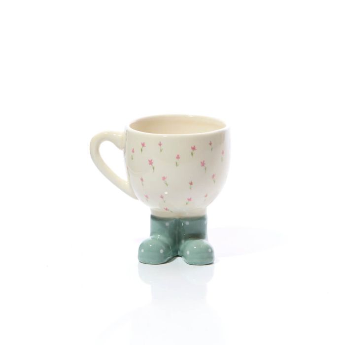 Ceramic mug with pink floral pattern and green boot-shaped base on a white background