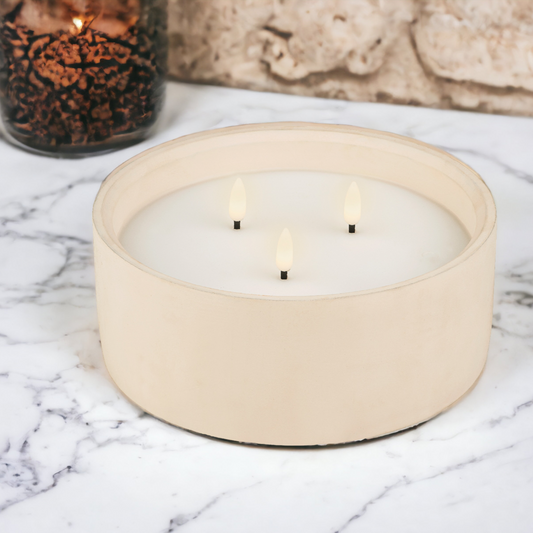 3 wick candle in a concrete pot on top of a marbles outside table with a candle and wall in background