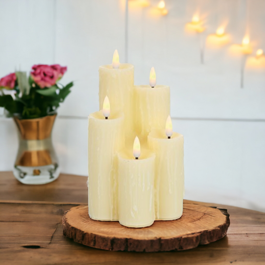 5 piece melted edge candle stack on top of a wooden tray with a vase of flowers in the background