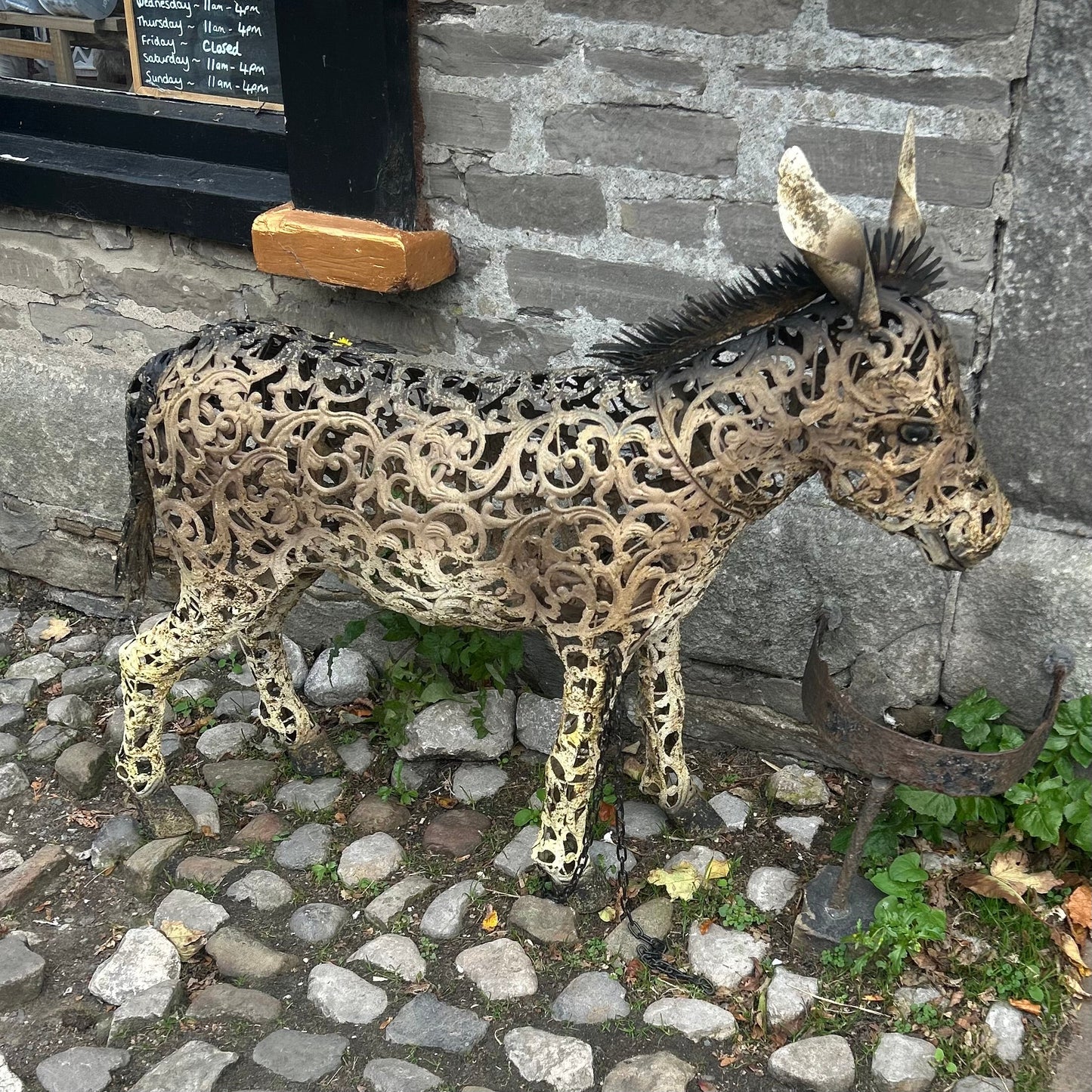 Decorative metal donkey sculpture on a stone pavement
