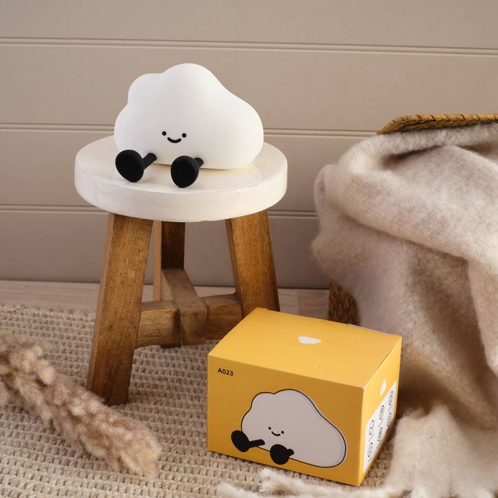White cloud-shaped lamp on a small wooden stool with a matching box on the floor.