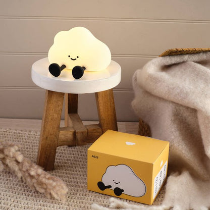 Cute cloud-shaped night light on a small stool next to its packaging box.