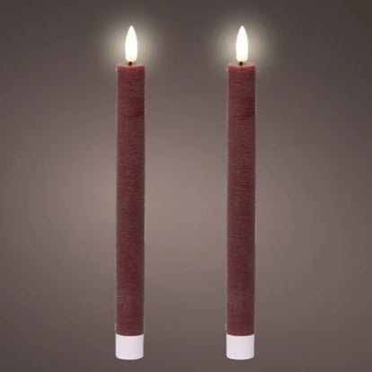 A pair of Oxblood red flat top LED wax dinner candles with a warm white glow, set against a grey background.