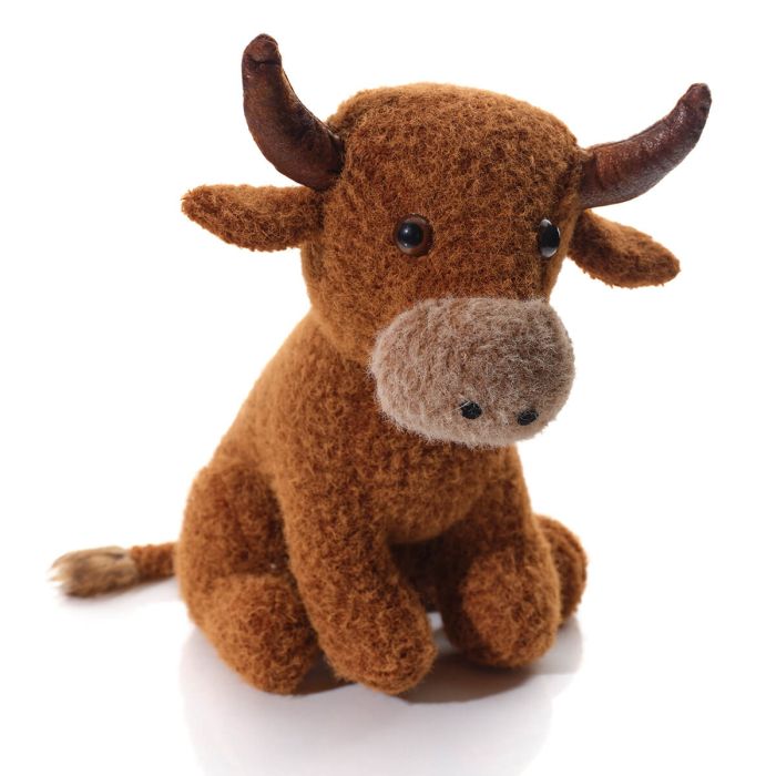 Brown stuffed highland cow door stop on a white background