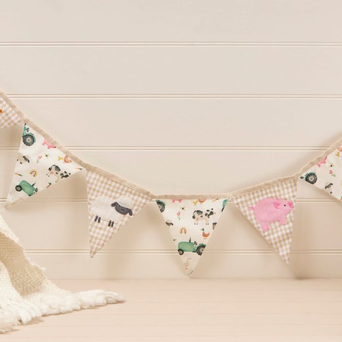 Fabric bunting with animal patterns hanging against a light wooden wall.