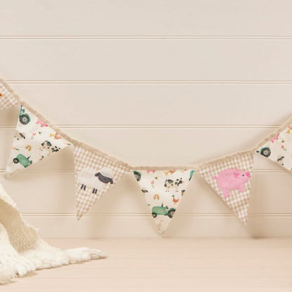 Fabric bunting with animal patterns hanging against a light wooden wall.