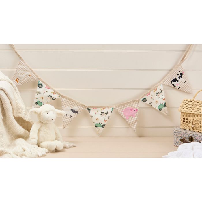 Children's room with a toy, blanket, and decorative banner on a wooden floor.