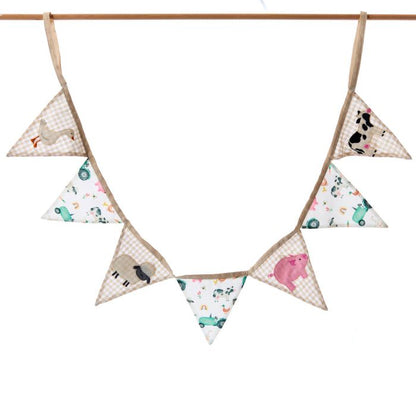 Triangle-shaped fabric flags with animal patterns hanging on a wooden rod against a white background