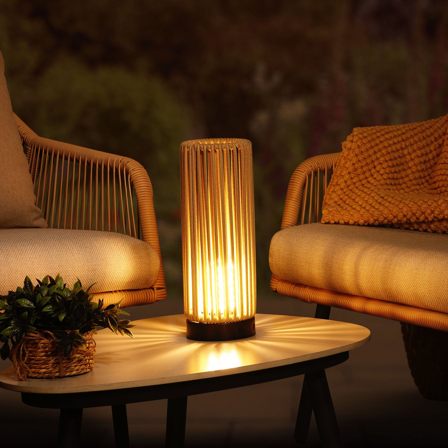 Cozy outdoor setting with wicker chairs, a table, and a lit lantern.