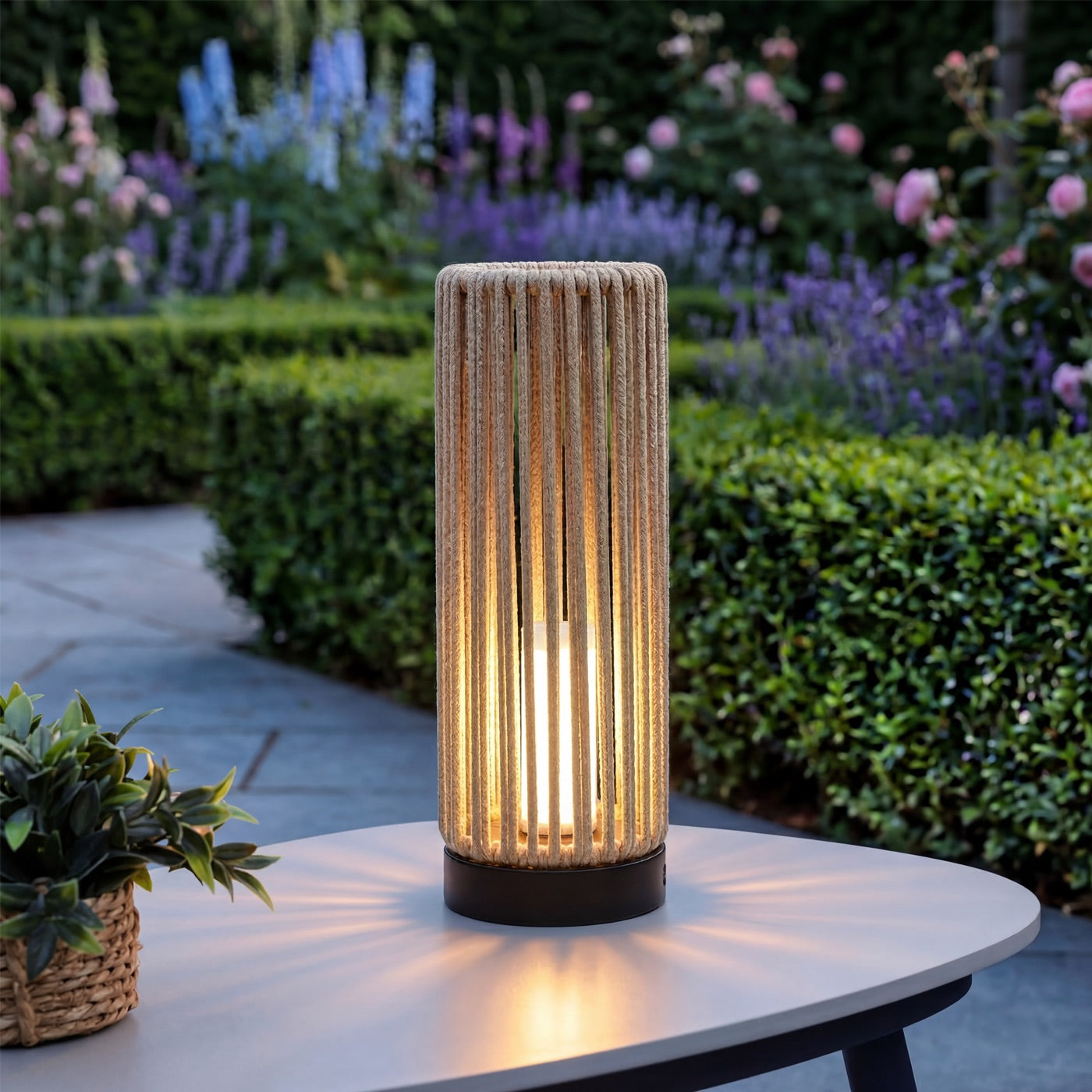 Decorative outdoor lamp on a table with garden in the background