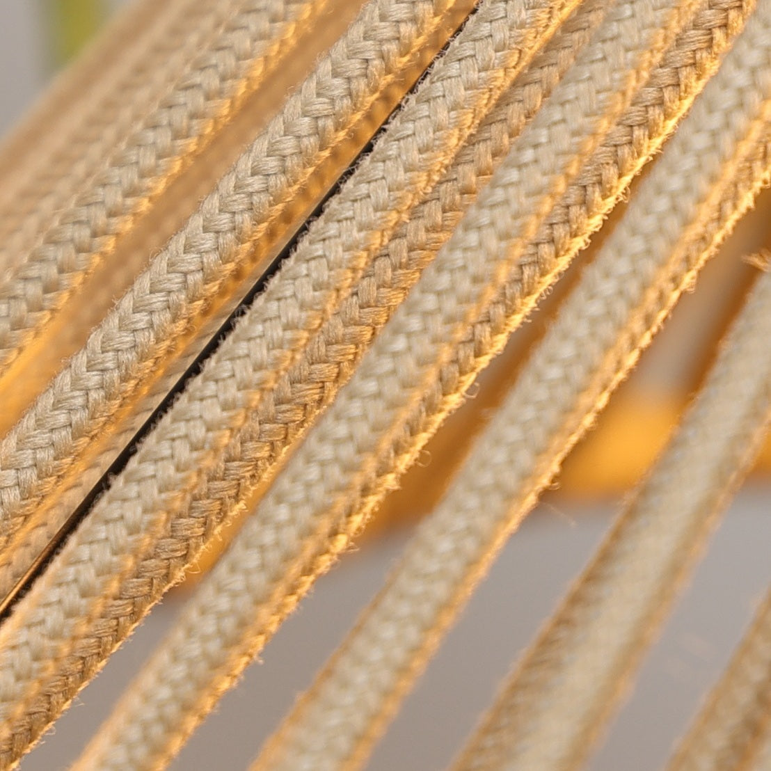 Close-up of beige and gold braided cable on a blurred background
