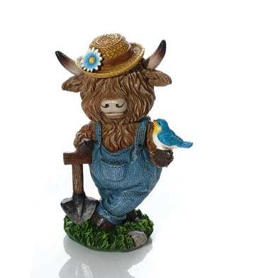 Statue of a cow wearing a hat with a flower, overalls, and holding a bird on a white background