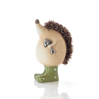Hedgehog figurine wearing green rain boots on a white background