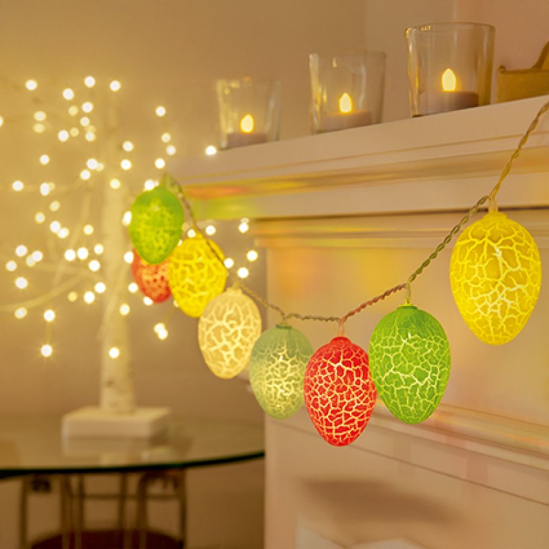 Decorative string lights with colorful egg-shaped bulbs in a warm indoor setting.