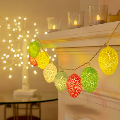 Decorative string lights with colorful egg-shaped bulbs in a warm indoor setting.