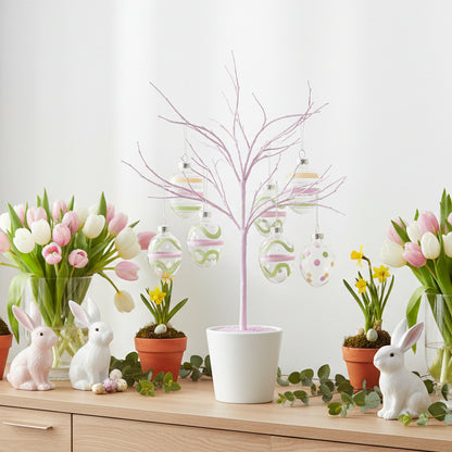 Decorative Easter scene with tulips, rabbits, and a tree on a wooden surface.