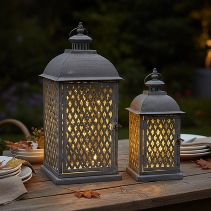 Two illuminated outdoor lanterns on a wooden table with a blurred natural background