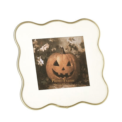 Decorative gold wavy edge photo frame on a white background